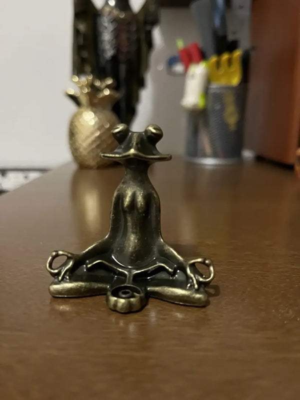 Bronze figurine of a hand on a star-shaped base on a wooden surface. decor aurawork