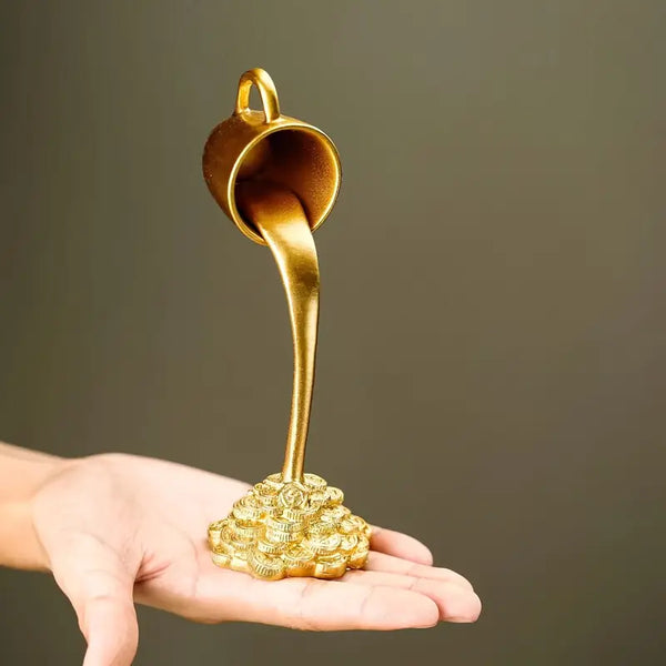 Gold-colored object resembling a honey dipper on a hand against a dark background  decor aura works