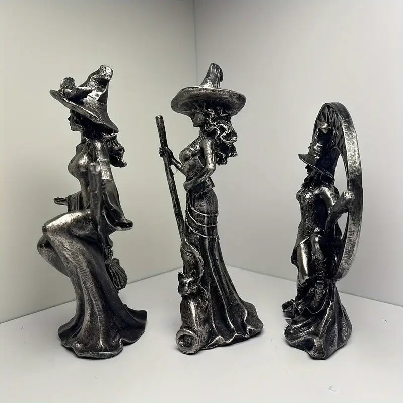 Three metallic witch figurines with brooms on a white background decor auraworks