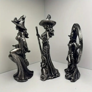 Three metallic witch figurines with brooms on a white background decor auraworks