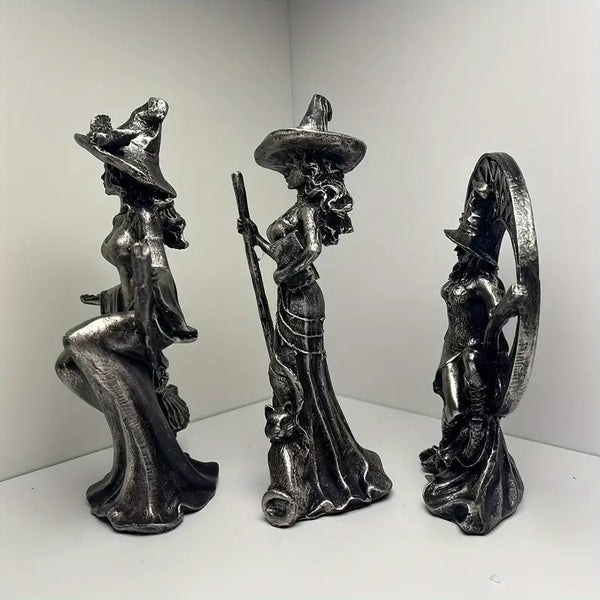 Three metallic witch figurines with brooms on a white background decor auraworks