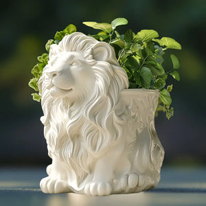 White lion-shaped planter with green plants against a blurred background vase auraworks