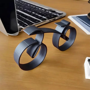 Black metal desk organizer on a wooden desk with laptop and tablet in the background