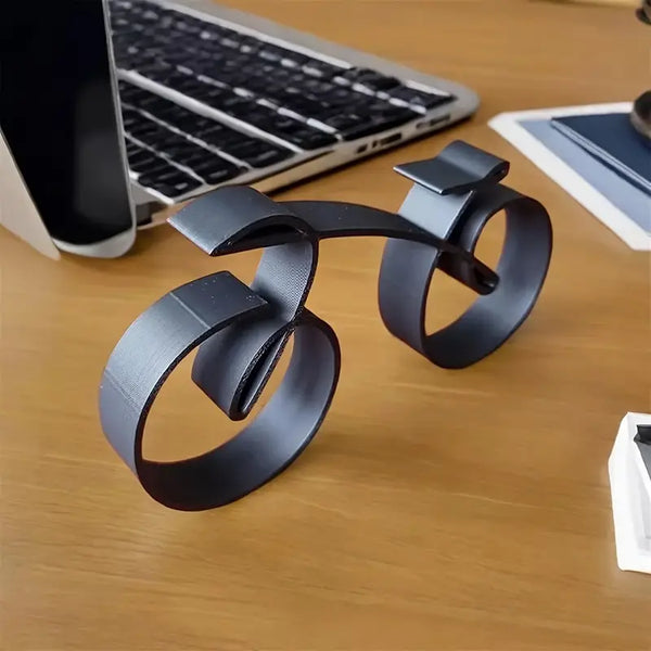 Black metal desk organizer on a wooden desk with laptop and tablet in the background