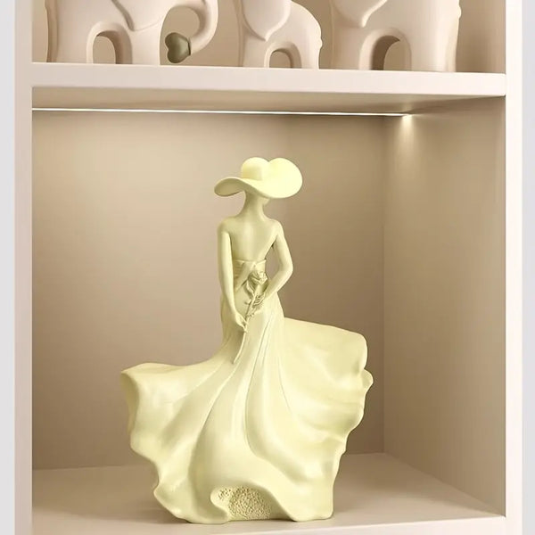 Decorative figurine of a woman in a flowing dress on a shelf.