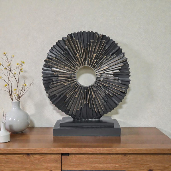 Decorative sunburst sculpture on a wooden surface with a neutral background Aura Works
