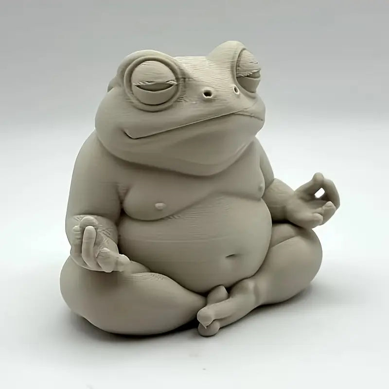 Ceramic frog sculpture in a meditative pose on a white background