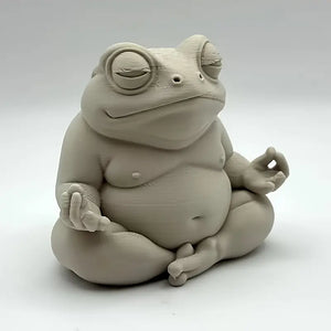 Ceramic frog sculpture in a meditative pose on a white background