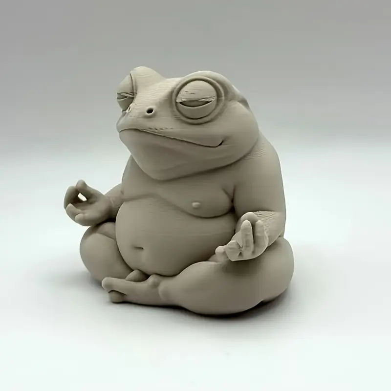 Ceramic frog sculpture in a meditative pose on a white background