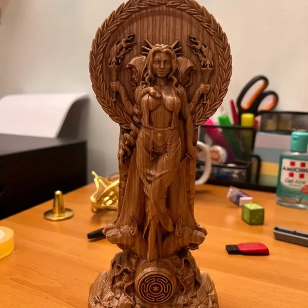 Wooden statue of a deity between two lit candles on a dark surface with  flowers. auraworks Decor