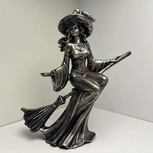 Metallic witch figurine with a broom on a white background decor aura works