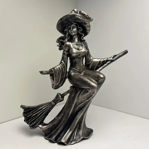 Metallic witch figurine with a broom on a white background decor aura works