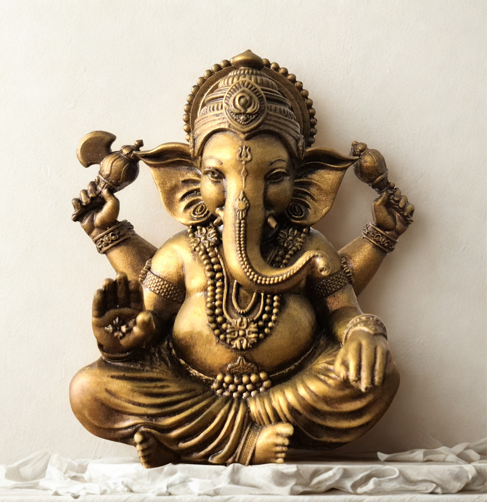 Front view of a handcrafted brass Lord Ganesha idol in a blessing pose, seated peacefully with intricate detailing, placed on a white cloth background — perfect for home decor, spirituality, and gifting. auraworks