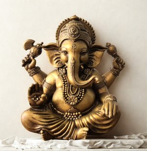 Front view of a handcrafted brass Lord Ganesha idol in a blessing pose, seated peacefully with intricate detailing, placed on a white cloth background — perfect for home decor, spirituality, and gifting. auraworks