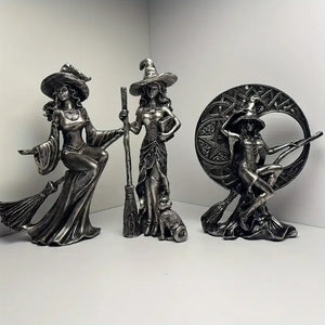 Three metallic witch figurines with brooms on a white background decor auraworks